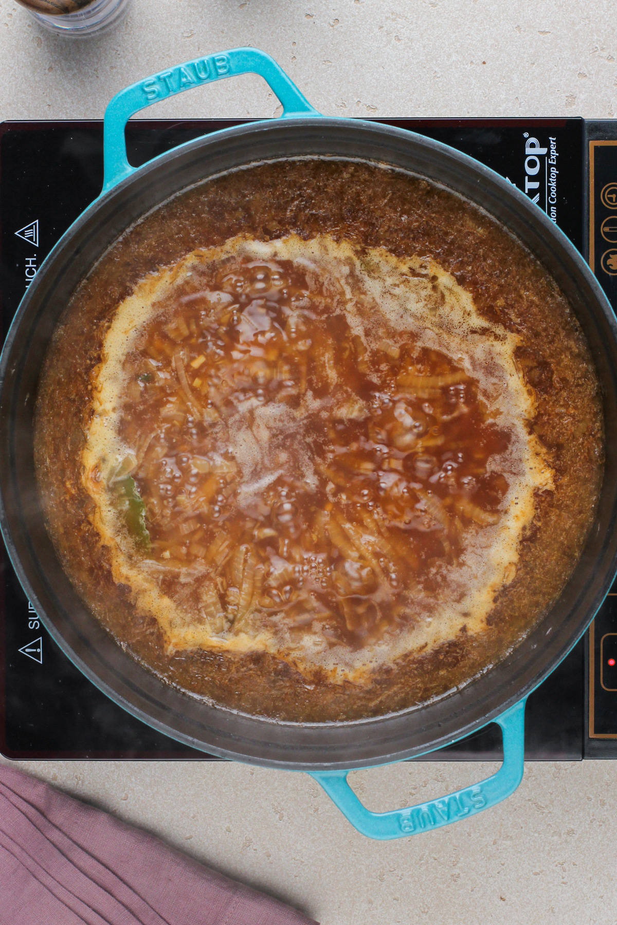 French onion soup simmering in a dutch oven.