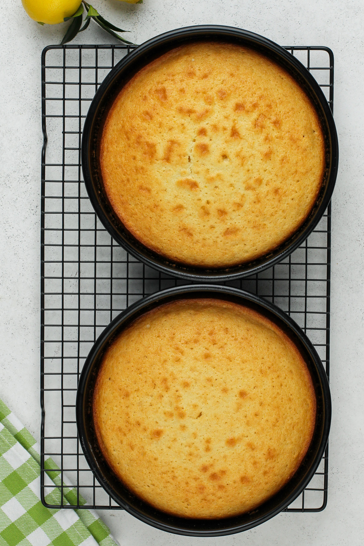 Baked lemon cake layers cooling on a wire rack.