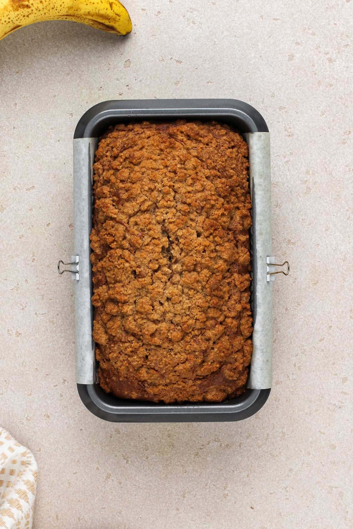 Baked loaf of sour cream banana bread in a loaf pan.