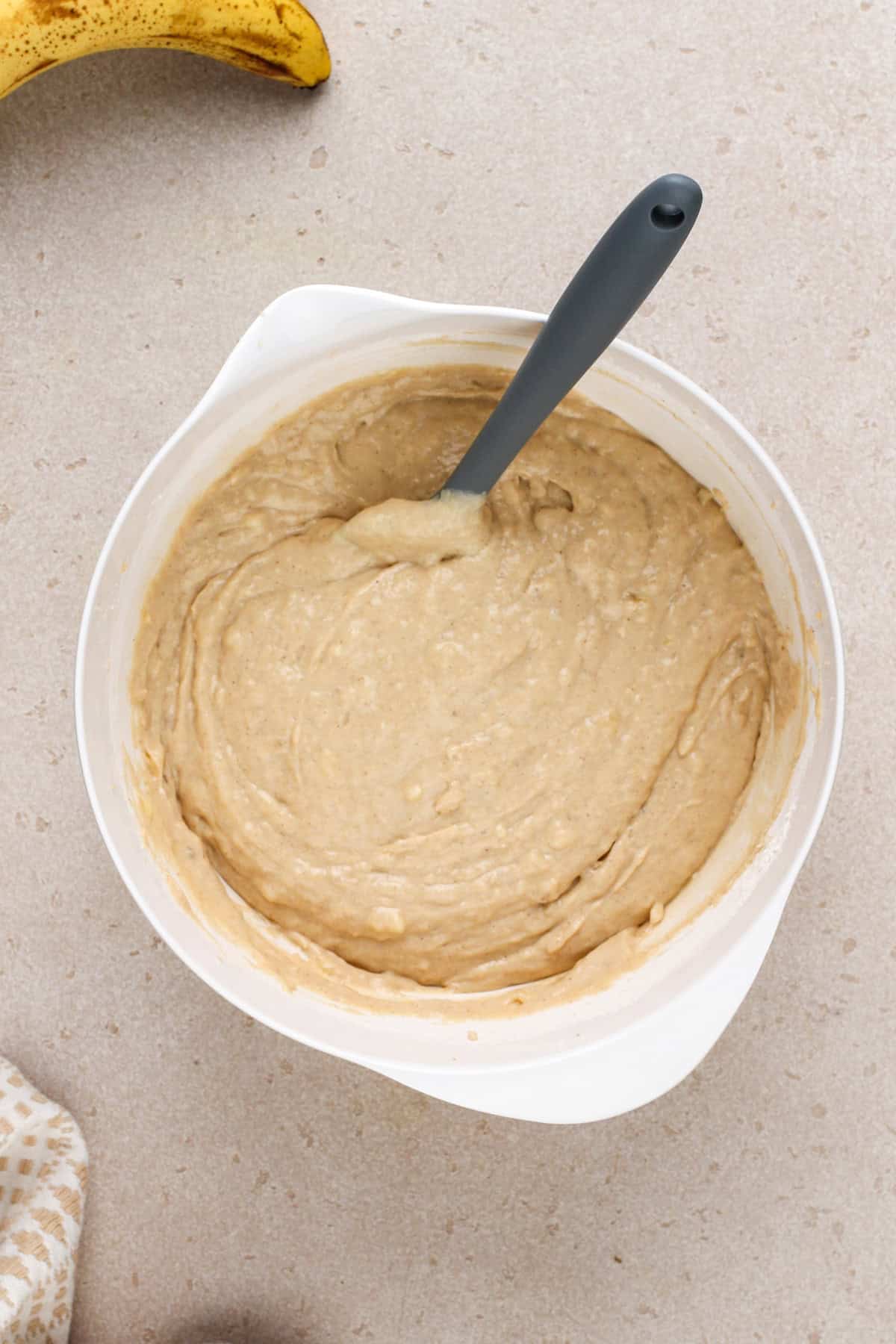 Sour cream banana bread batter in a white bowl.