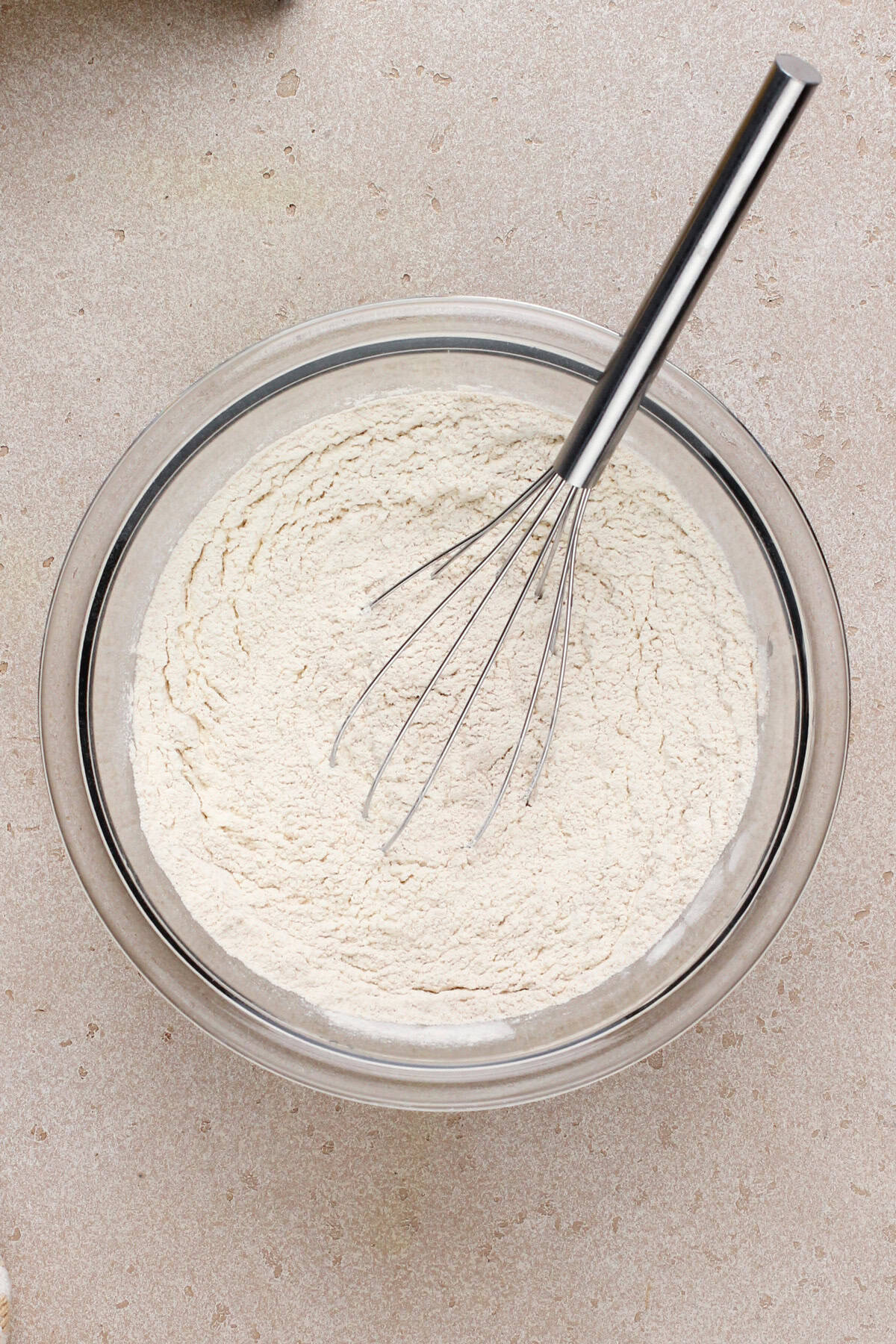 Dry ingredients for sour cream banana bread whisked in a glass bowl.