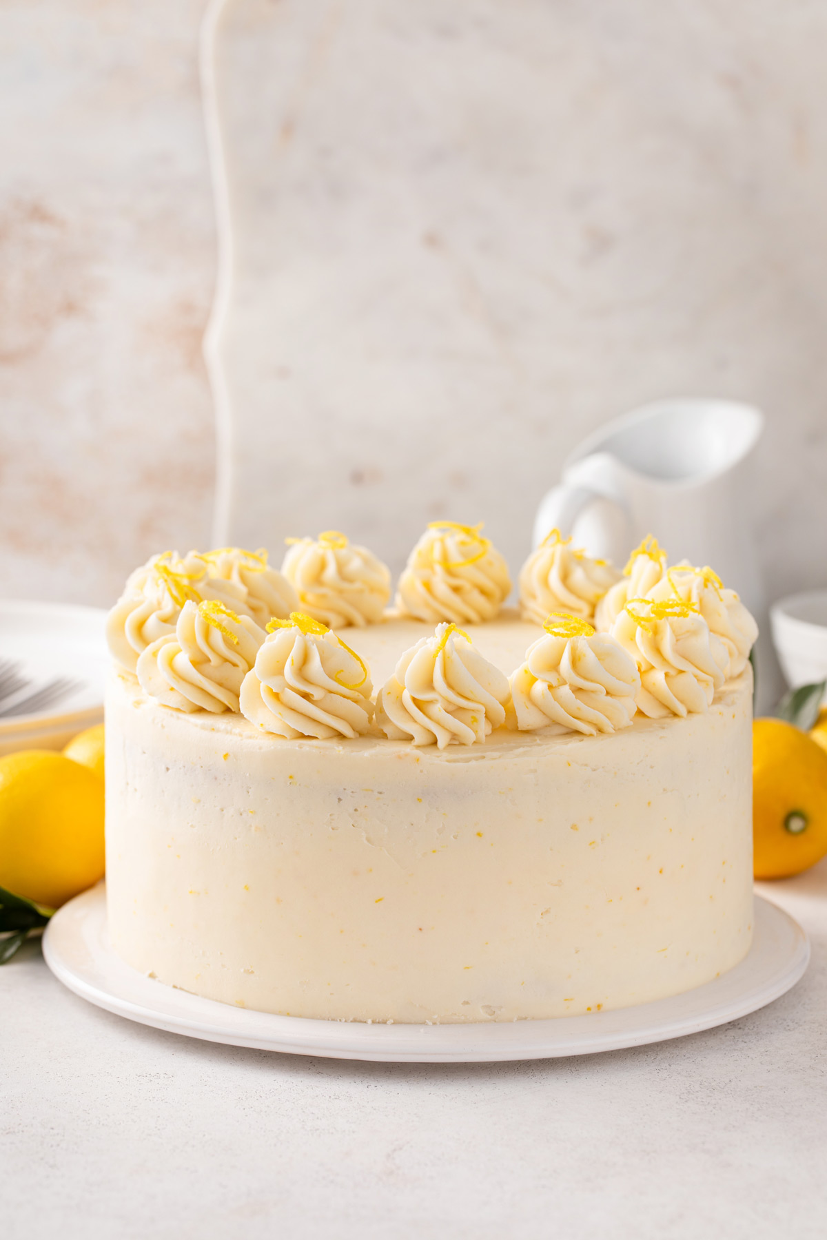 Decorated lemon layer cake on a white cake plate.