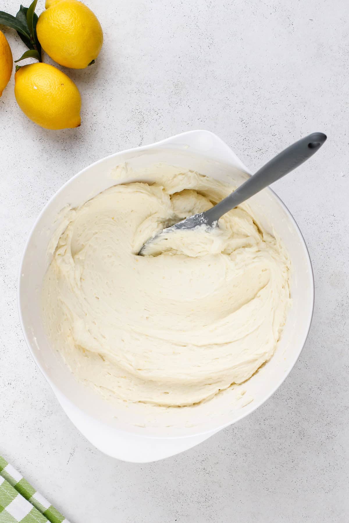 Freshly mixed lemon buttercream in a white mixing bowl.