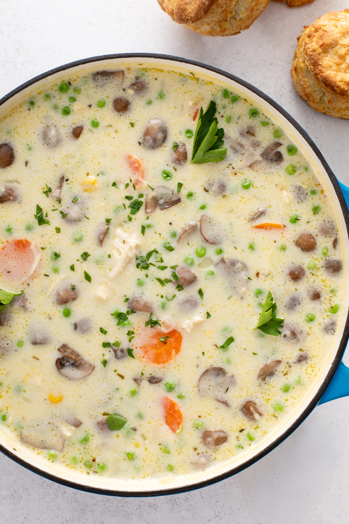 Chicken pot pie soup in a blue dutch oven.