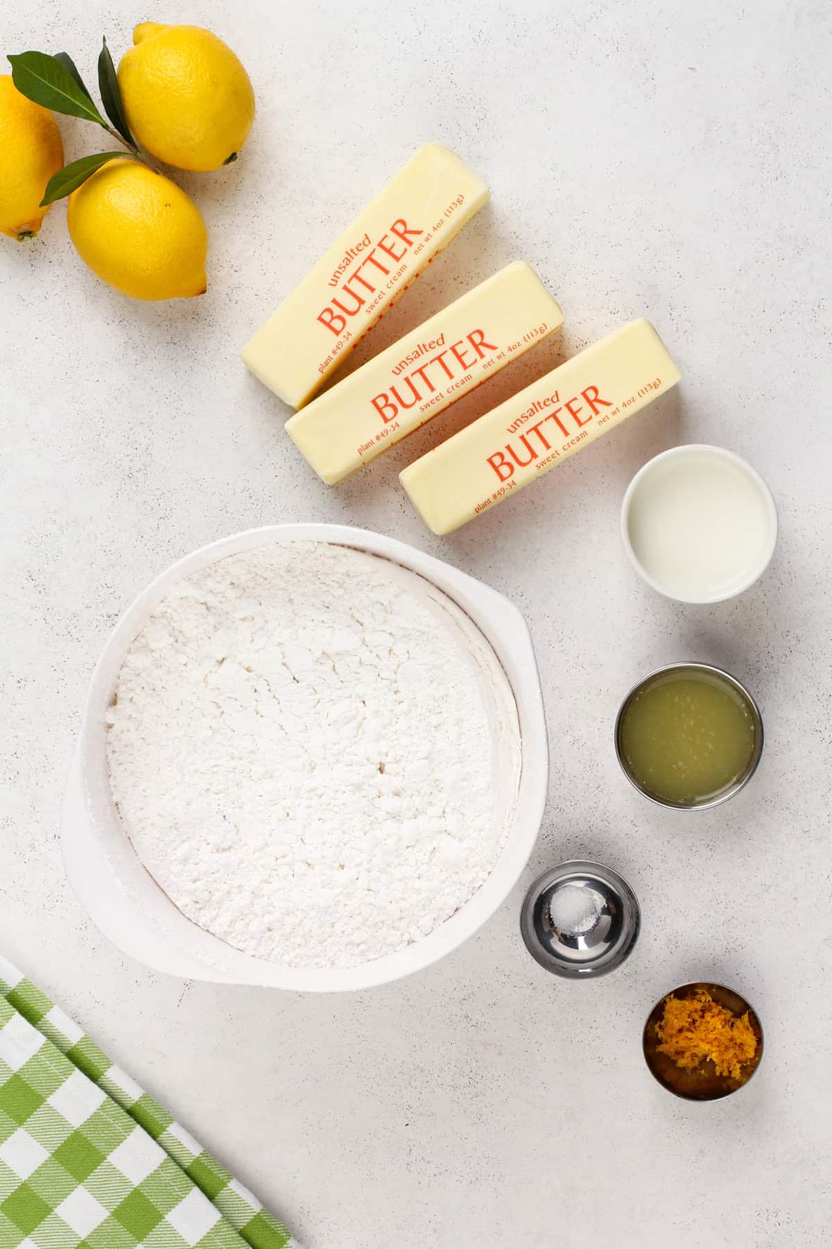 Ingredients for lemon buttercream frosting arranged on a countertop.