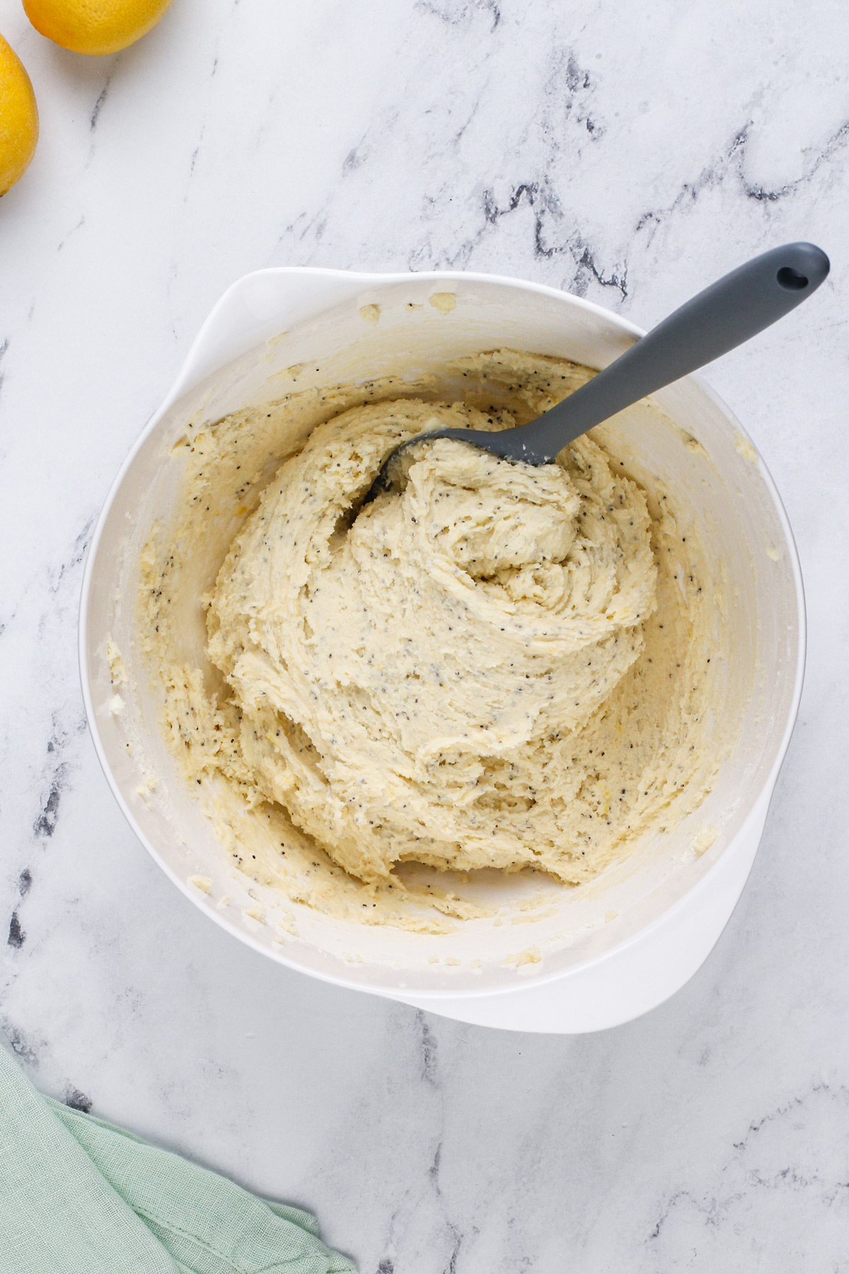 Lemon poppy seed cookie dough in a white mixing bowl.