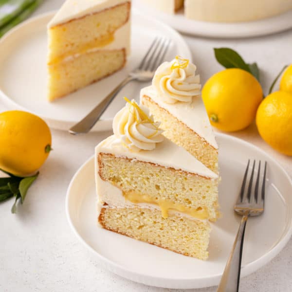 Slices of lemon layer cake on white plates.