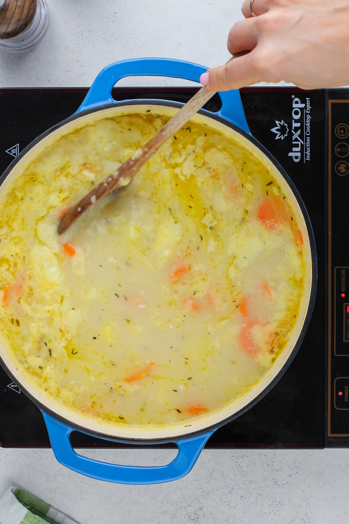 Chicken pot pie soup simmering on a burner.