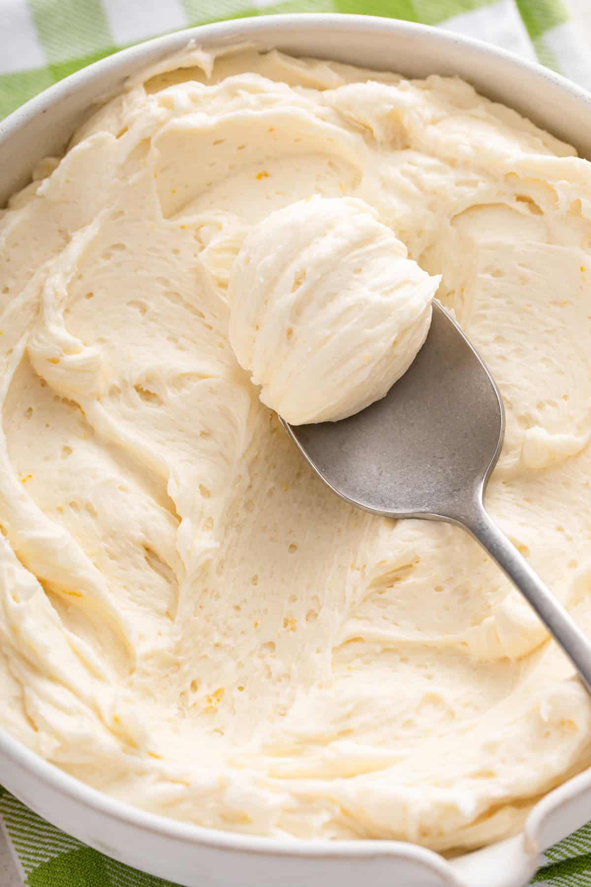 Spoon in a bowl of lemon buttercream frosting.